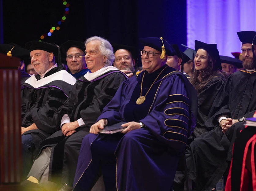 Eric Alexander, Henry Winkler, and Emerson College President Jay Bernhardt listen to a speech during the Commencement ceremony.