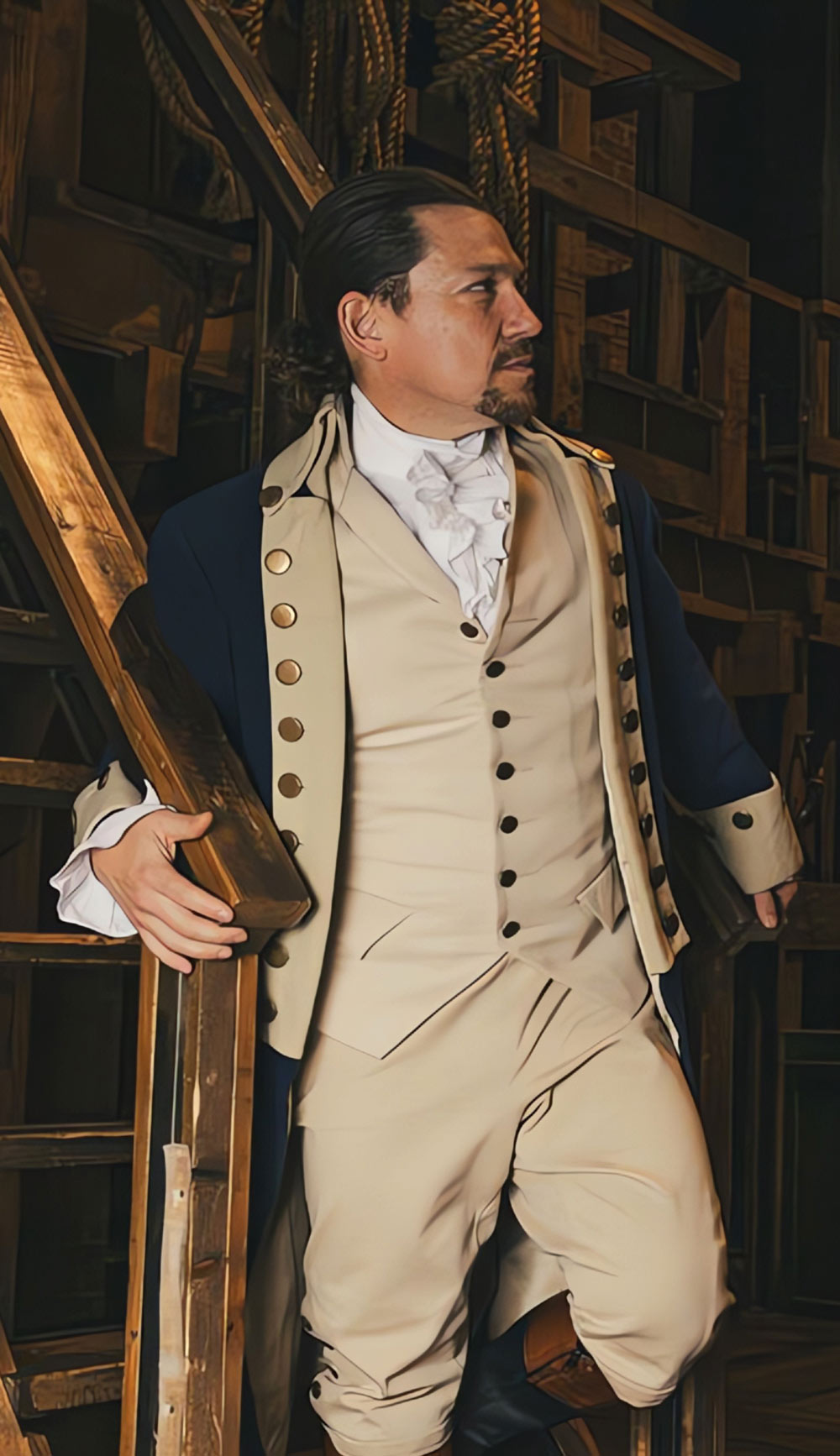 Miguel Cervantes in 18th-century period costume leaning on wooden stairs on a stage set.