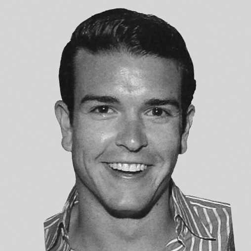Black-and-white headshot of a smiling Gray Malin wearing a striped shirt.