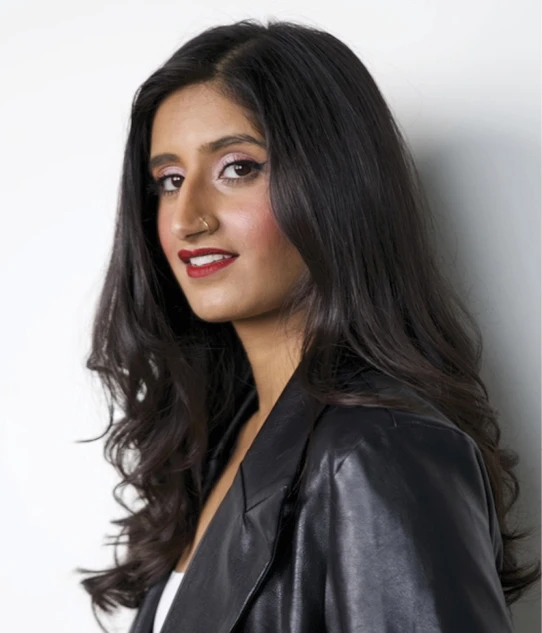 Portrait of a woman with long dark hair wearing a black leather jacket against a white background.
